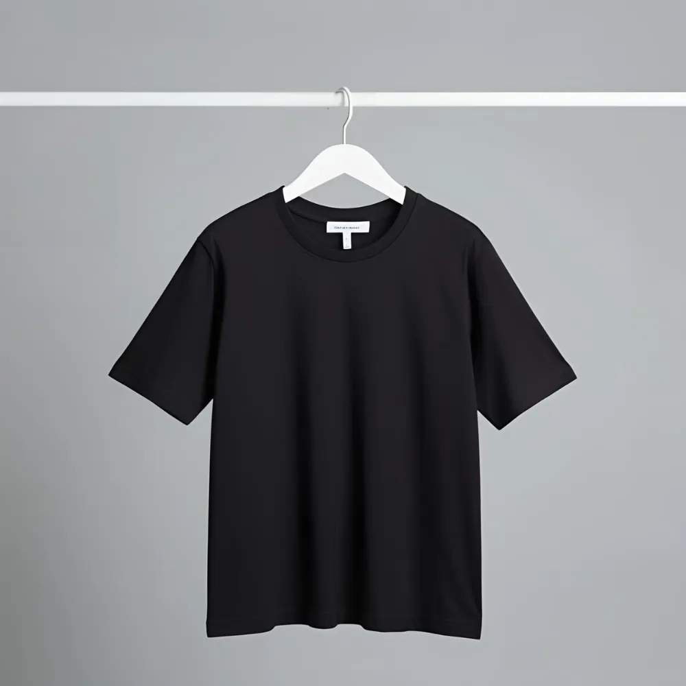 Sleek black essential t-shirt hanging on a white hanger.